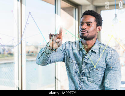 Casual Geschäftsmann berühren Glasscheibe mit Diagramm im Büro Stockfoto