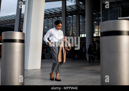 Lächelnde Geschäftsfrau Blick auf Handy Stockfoto