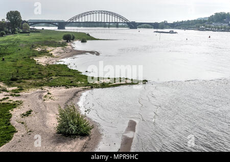 Sandstrände entlang des Flusses Waal in der Nähe von Nijmegen, Niederlande mit der waalbrücke im Hintergrund Stockfoto