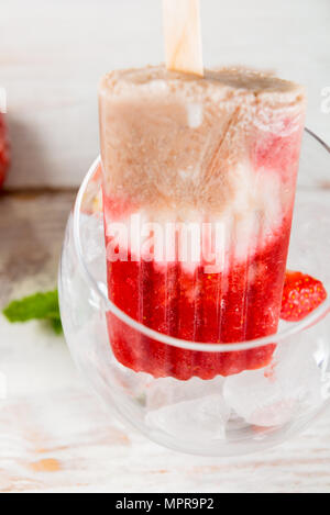 Hausgemachte Vegan Erdbeere Popsicle aus Erdbeersaft und Kokosmilch auf hellen Hintergrund. Sommer essen Konzept. Ansicht von oben. Stockfoto