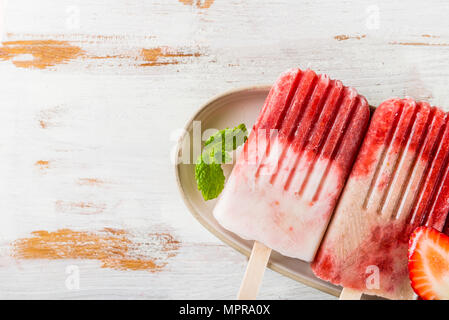 Hausgemachte Vegan Erdbeere Popsicle aus Erdbeersaft und Kokosmilch auf hellen Hintergrund. Sommer essen Konzept. Ansicht von oben. Stockfoto