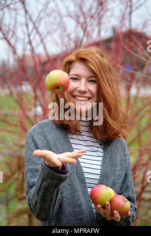 Portrait von rothaarigen Mädchen im Teenageralter mit vier Äpfel Stockfoto