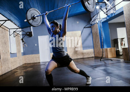 Frau heben Langhantel im Fitness-Studio Stockfoto