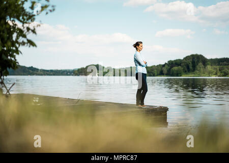 Frau stehend auf Steg am See Stockfoto