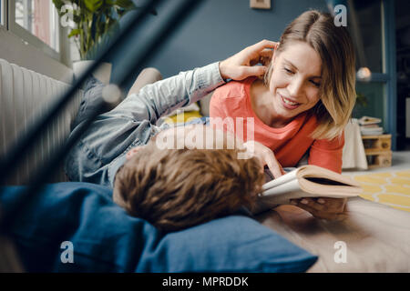 Glückliches Paar Lesen und Kuscheln zu Hause Stockfoto