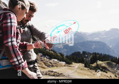 Junges Paar mit einer Unterbrechung von Wandern die Kontrolle der Angaben, die sich aus der Zukunft Stockfoto