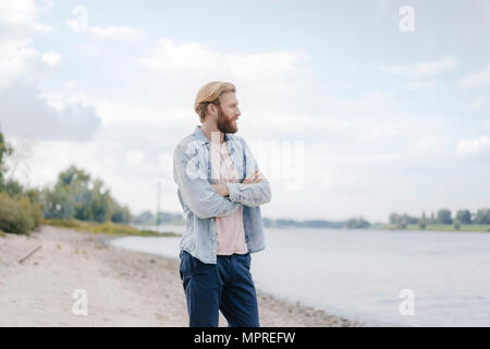 Deutschland, Duesseldorf, Mann stand am Flußufer auf Anzeigen Stockfoto