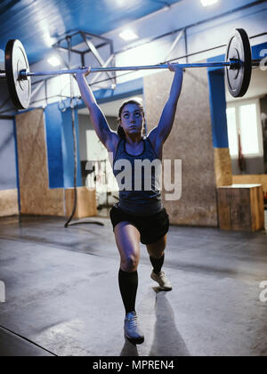 Frau heben Langhantel im Fitness-Studio Stockfoto