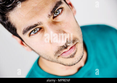 Portrait von ernsthaften jungen Mann mit blauen Augen und der Arbeitsscheinwerfer zur Kontrolle der Schnitthöhe Stockfoto