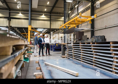 Drei Männer Tragen von Schutzhelmen auf Factory Shop Boden Stockfoto