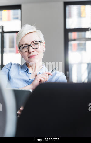 Porträt der lächelnde Frau mit Brille im Büro Stockfoto