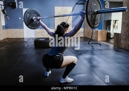 Frau heben Langhantel im Fitness-Studio Stockfoto