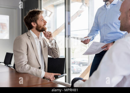 Drei Unternehmer diskutieren in Konferenzraum Stockfoto