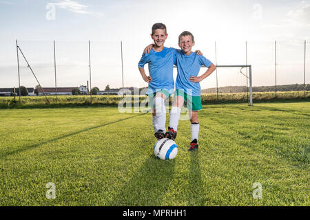 Lächelnde junge Fußball-Spieler auf den Fußballplatz umarmen Stockfoto