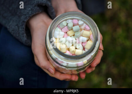 Hände halten Glas Marshmallows, close-up Stockfoto