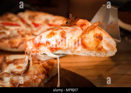 Fast food traditionellen italienischen. Scheibe Hot Chicken Sausage Pizza mit Käse auf Holzbrett Tabelle Klassiker in Seitenansicht. geschlossen. Kopieren. Stockfoto