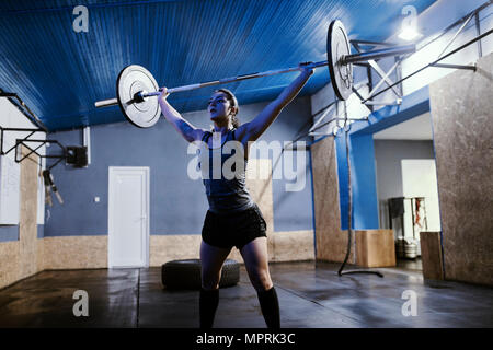 Frau heben Langhantel im Fitness-Studio Stockfoto