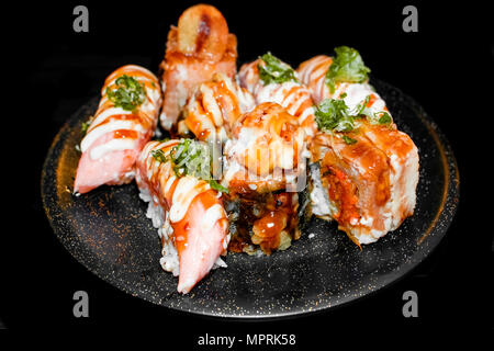 Sushi Set Sashimi und Sushi Rollen auf schwarzen Stein Schiefer serviert. In der Nähe. Stockfoto