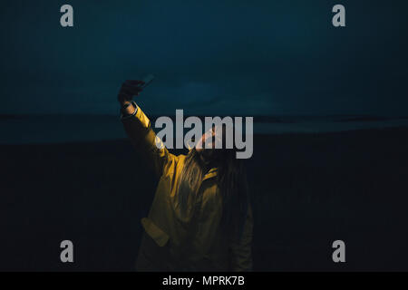 Frankreich, Bretagne, Landeda, Dünen de Sainte-Marguerite, Frau eine selfie am Strand bei Nacht Stockfoto