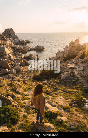 Italien, Sardinien, Frau auf eine Wanderung steht auf Felsen an der Küste Stockfoto