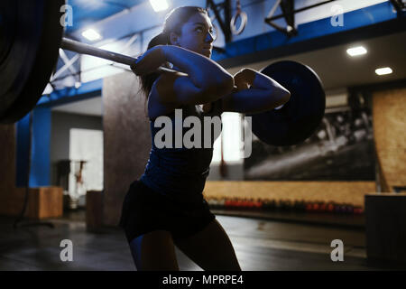 Frau heben Langhantel im Fitness-Studio Stockfoto