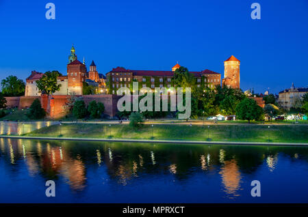 Polen, Krakau. Beleuchtete königliche Schloss Wawel und Dom bei Nacht und ihre Reflexion in der Weichsel. Riverside mit Park, Bäume, Promenade und l Stockfoto