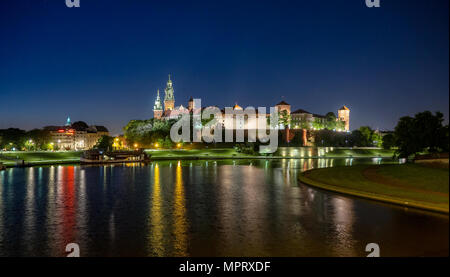 Polen, Krakau. Beleuchtete königliche Schloss Wawel und Dom bei Nacht und Lichtreflexe in die Weichsel. Riverside mit Park, Bäume, Promenade, l Stockfoto