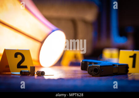 Eine Feuerwaffe und andere Beweise ist mit Markierungen auf dem Fußboden eines Hauses gekennzeichnet. Ein Umgeworfen Lampe legt in der Nähe. Stockfoto
