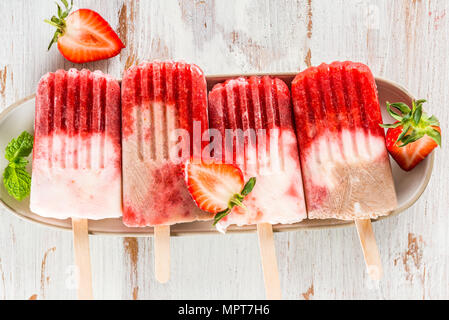 Hausgemachte Vegan Erdbeere Popsicle aus Erdbeersaft und Kokosmilch auf hellen Hintergrund. Sommer essen Konzept. Ansicht von oben. Stockfoto