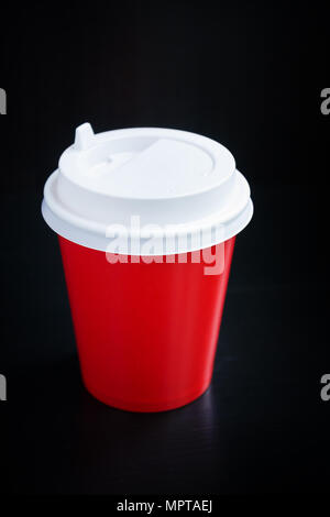 Rote Kaffeetasse auf schwarzem Hintergrund. Coffee to go Stockfoto