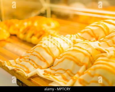 Closeup selektiven Fokus von frisch gebackenem Brot in Fach Rack. Essen und Trinken Konzept. Stockfoto