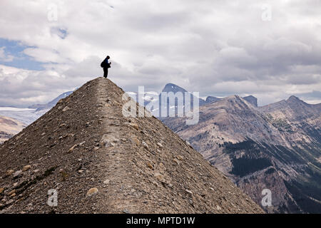 Eine silhouette Ansicht eines anonymen Wanderer steht auf einem kleinen Hügel wie eine Pyramide vor der Kanadischen Rockies im Yoho National Park geprägt. Stockfoto