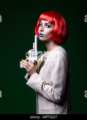 Porträt der jungen Frau in den komischen Pop art Make-up Stil. Frau mit Waffe in der Hand. Stockfoto