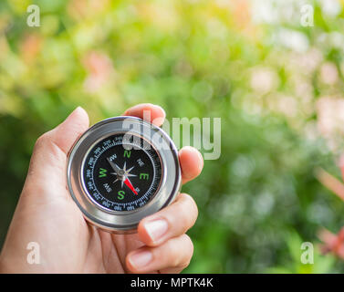 Closeup hand Kompass mit Baum Blätter bokeh Hintergrund. Stockfoto