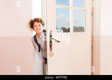 Gerne Jugendliche Junge mit Schultasche durch die Tür, aus der Schule nach Hause kommen Stockfoto