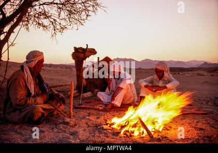 Sinai, Ägypten; Beduinen am Lagerfeuer, traditionelle Musiker links Stockfoto