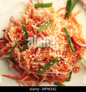 Vegan Salat mit Karotten und Rettich. Ansicht von oben. Asiatische Küche. Gesunde vegane Vorspeise auf die runde Platte. Beilage. Vegetarisches Gericht. Getönten square phot Stockfoto