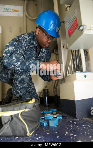 NEWPORT NEWS, Virginia (27. März 2017) Personalreferentin 3. Klasse Papa Tandoh aus Aberdeen, Maryland, arbeitet auf einem Multi-Kabel-Transit als Teil eines Kabel-Teams an Bord der Flugzeugträger der Nimitz-Klasse USS Abraham Lincoln (CVN-72). Abraham Lincoln ist in der Endphase eines vierjährigen tanken und komplexen Überholung und wird wieder zur Flotte Anfang 2017 geliefert werden. (Foto: U.S. Navy Mass Communication Specialist 3. Klasse Aaron T. Kiser/freigegeben) Stockfoto