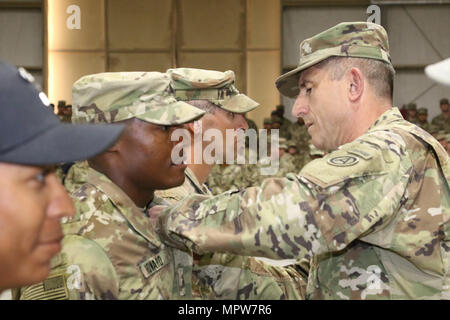 US-Armee Generalmajor William Hickman (rechts), stellvertretender Kommandierender general der US Army Central, Stifte Luft Angriff Flügel auf eines der Air Assault Course Ehren Absolventen Sgt. Carl Howard, combat Medic, 215. Brigade Support Battalion, 3rd Armored Brigade Combat Team, 1. Kavallerie-Division, während Graduation Days, 14. April 2017, im Camp Beuhring, Kuwait. Air Assault Course ist eine 12-Tage-Klasse, die U.S. Soldaten in der US-Armee zentrale Einsatzgebiet die einzigartige Möglichkeit ermöglicht, Luftangriff werden qualifizierte sich außerhalb der Vereinigten Staaten eingesetzt. Stockfoto