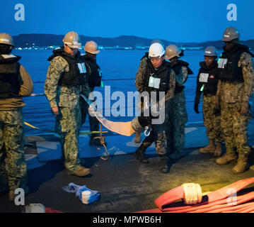 POHANG, Südkorea (11. April 2017) – Segler aus amphibischen Bau-Bataillon 1 und ROK Seabees von Naval Mobile Bau-Bataillon 2 bewegen eine Schlauch Befestigung für die amphibische Bulk Liquid Transfer System während der Operation Pazifik erreichen Übung 2017 (OPRex17). OPRex17 ist eine bilaterale Fortbildungsveranstaltung zur Bereitschaft zu gewährleisten und aufrechtzuerhalten der ROK-US-Allianz durch ein Bereich Distribution Center (ADC), ein Air Terminal liefern Punkt (AZP), kombinierte gemeinsame Logistik Over-the-Shore (CJLOTS), und die Nutzung der Schiene, Binnengewässer und Küsten Liftbetrieb zur Validierung der o Stockfoto