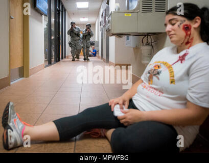 Flieger vom 96. Security Forces Squadron, hin zu einer verwundeten Opfer während eines aktiven shooter Übung in Eglin Air Force Base, Fla., April 11. Ziel der Übung war es, das Wissen des Menschen und die Reaktion an der aktiven shooter Speicherort, und wählen Sie die Option Sperrmodus Standorten zu bewerten. Stockfoto