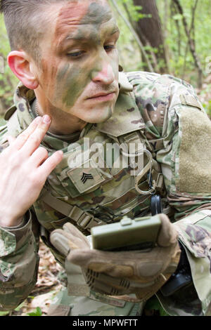 Sgt. Wilson Jackson, ein Bewohner von Houston, Texas und Mitglied der 45. Infantry Brigade Combat Team Teilnahme an der 7. Armee Traning Befehl Unteroffizier Academy Leader Grundkurs während in die Ukraine, gilt Tarnung während einer situativen Übung am Yavoriv Combat Training Center auf der internationalen Friedenssicherung und Security Center in der Nähe von Yavoriv, Ukraine, am 20. April. (Foto von Sgt. Anthony Jones, 45. Infanterie Brigade Combat Team) Stockfoto