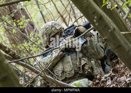 Sgt. Russell Blevins, wohnhaft in Broken Arrow, Oklahoma und Sanitäter mit der 45. Infanterie Brigade Combat Team bereitgestellt für die Ukraine, bietet Sicherheit für Kolleginnen und Soldaten während einer situativen Übung während der 7. Armee Traning Befehl Unteroffizier Academy Leader Grundkurs abgehaltenen Yavoriv Combat Training Center auf der internationalen Friedenssicherung und Security Center in der Nähe von Yavoriv, Ukraine , am 20. April. (Foto von Sgt. Anthony Jones, 45. Infanterie Brigade Combat Team) Stockfoto