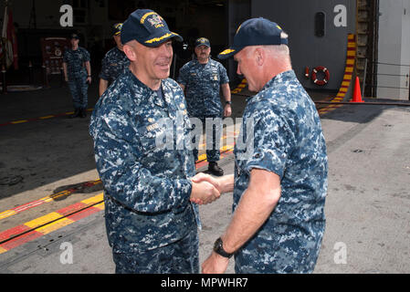 SASEBO, Japan (12. April 2017) Kapitän Jeffrey Ward, kommandierender Offizier der Amphibisches Schiff USS BONHOMME RICHARD (LHD6), grüßt Vice Adm. Thomas Rowden, Commander, Naval Surface Forces Pacific, bei seiner Ankunft auf dem Schiff. Bei seinem Besuch, Rowden met mit Bonhomme Richard, Base und Waterfront Senior Leadership bei einem Abendessen auf dem Schiff Wardroom. Rowden besucht Sasebo nach vorn, um besser zu verstehen, - Bereitschaft, Herausforderungen und die Lehren seines neuen Oberfläche Kraft Strategie Aktie - Zurück zum See. Stockfoto