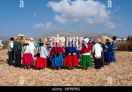 Lokale Uros mit Touristen in einem geistlichen Gebet Kreis, Titicacasee, Peru Stockfoto