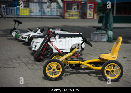 Autos mit Pedalen für Kinder stehen in einer Reihe Stockfoto