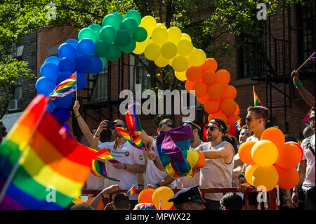 NEW YORK CITY - 25 Juni, 2017: Teilnehmer wave Regenbogenfahnen auf ein Schwimmer mit Ballon Bogen im Pride Parade durch Greenwich Village. Stockfoto
