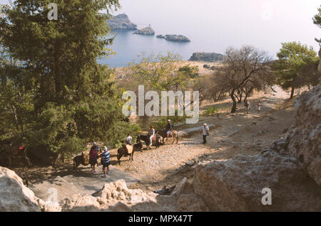 Lindos, Insel Rhodos, Griechenland - 18 September 2017: Touristen fahren die Esel in Lindos am Fuße der Akropolis. Stockfoto