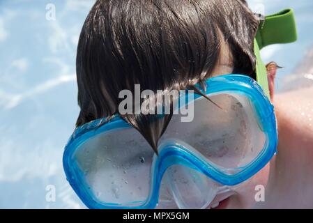 Schwimmen: identifizierbarer Junge ergibt sich aus Wasser tragen Schwimmbrille Stockfoto