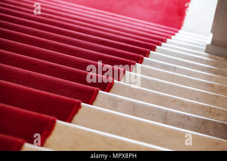 Roter Teppich legt auf weißem Marmor Treppe hinunter Stockfoto